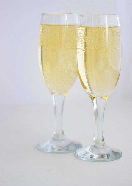 Deux verres de champagne sur fond blanc.