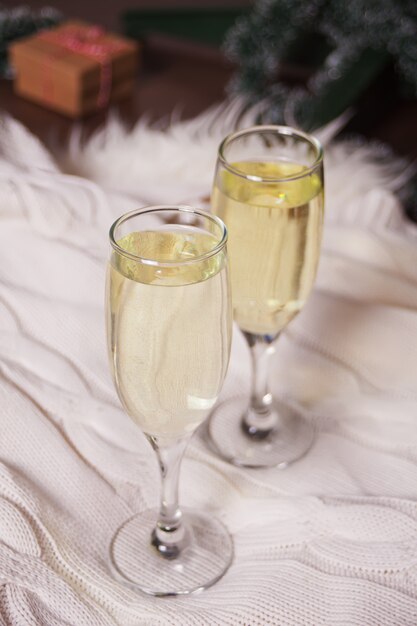 Deux verres de champagne sur un plaid de fourrure blanche