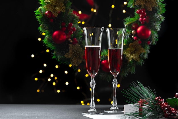 Deux verres de champagne remplis dans le contexte d'une guirlande de noël babbo natale uvlin uvgun j