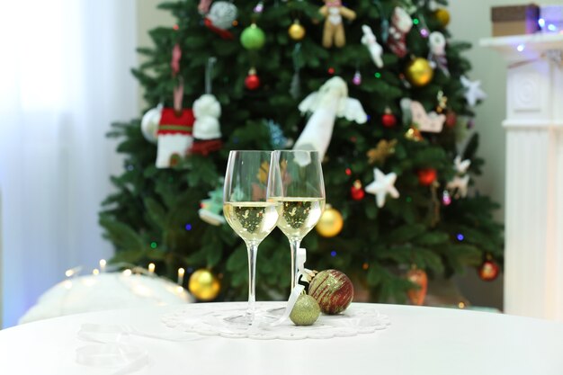 Deux verres de champagne sur la surface de l'arbre de Noël