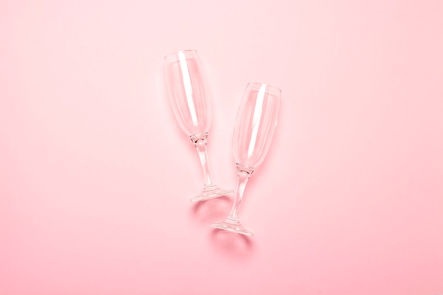 Deux verres de champagne vides sur un rose pâle