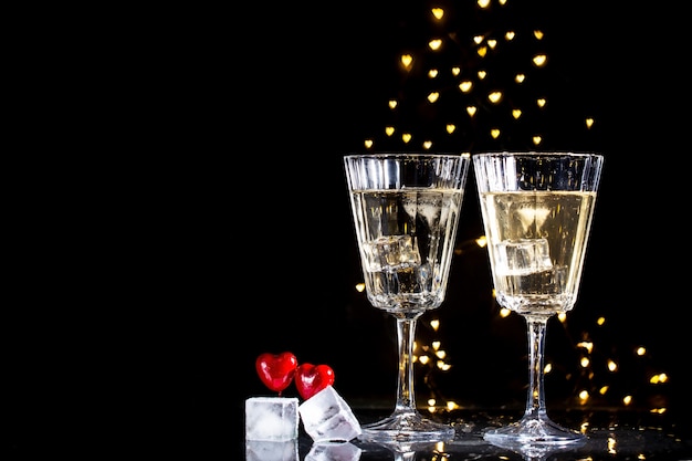 Deux verres avec un cocktail et deux coeurs, concept de la Saint-Valentin.