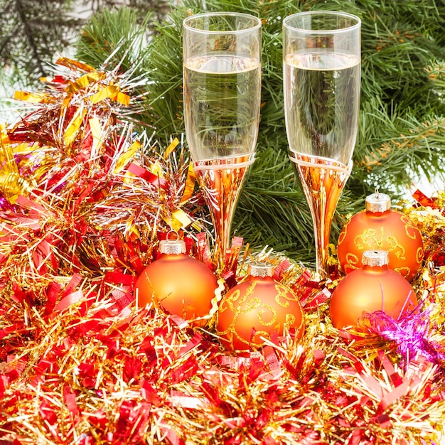 Photo deux verres avec décorations de noël dorées et arbre 6