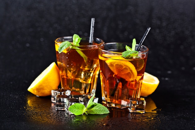 Deux verres avec du thé glacé traditionnel froid avec du citron, des feuilles de menthe et des glaçons.