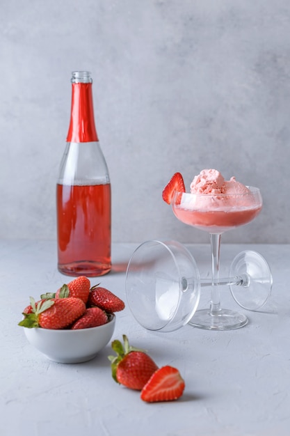 Deux verres de glace à la fraise et de champagne rose sur une surface grise. Concept de délicieuses boissons. Copiez l'espace.