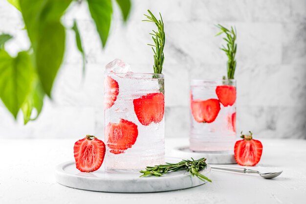 Deux verres highball collins de limonade pétillante rafraîchissante à la fraise et au romarin. Image horizontale claire et lumineuse.
