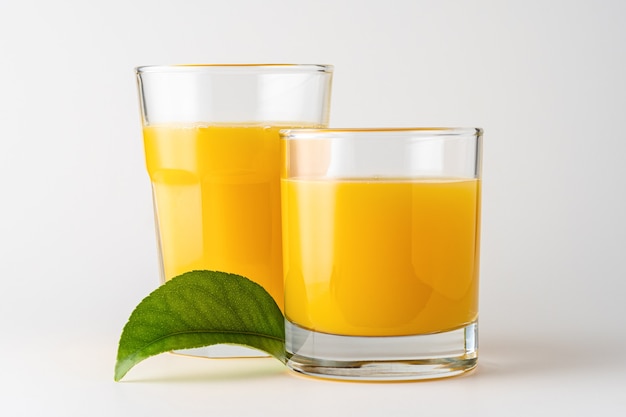 Deux verres de jus d'orange sur fond blanc