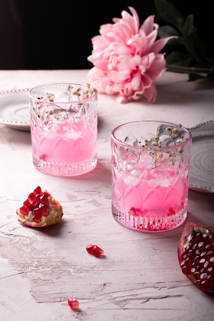 Deux verres de limonade de grenade rose sur un tableau blanc
