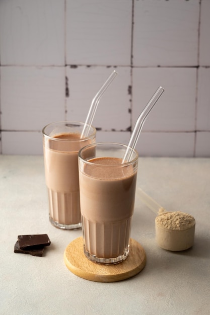 Deux verres de milkshake au chocolat avec une paille sur le dessus.