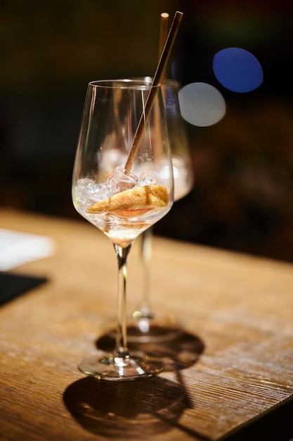 Deux verres à moitié vides avec de la glace et une tranche d'orange se tiennent sur une table dans un bar