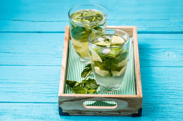 Deux verres de mojito dans une boîte en bois à la menthe