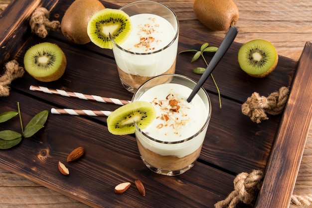 Deux verres avec un smoothie de banane aux fruits vitaminés aux amandes sur un plateau en bois un petit-déjeuner ou une collation sain