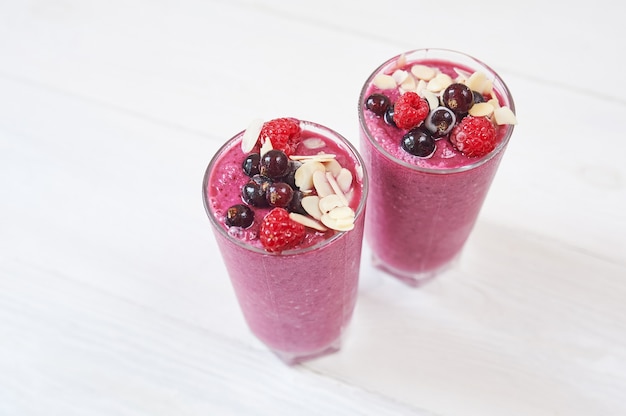 Deux verres de smoothies aux fruits roses milkshake ou smoothie ou cocktail sur un fond en bois blanc