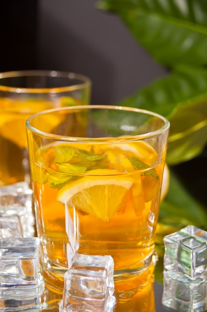 Deux verres de thé rafraîchissant froid avec de la glace et des fruits citronnés.