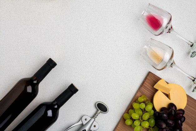 Deux verres de vin blanc et rouge, fromage et raisins vue de dessus