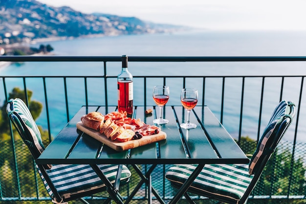 Deux verres de vin et des collations italiennes avec une vue imprenable au coucher du soleil en Italie Dîner romantique pour deux sur une terrasse panoramique