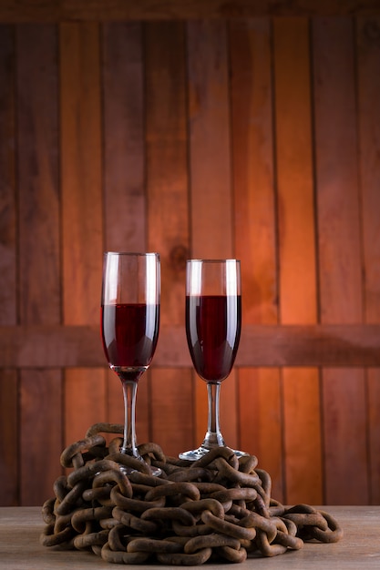 deux verres de vin sur fond en bois et chaîne