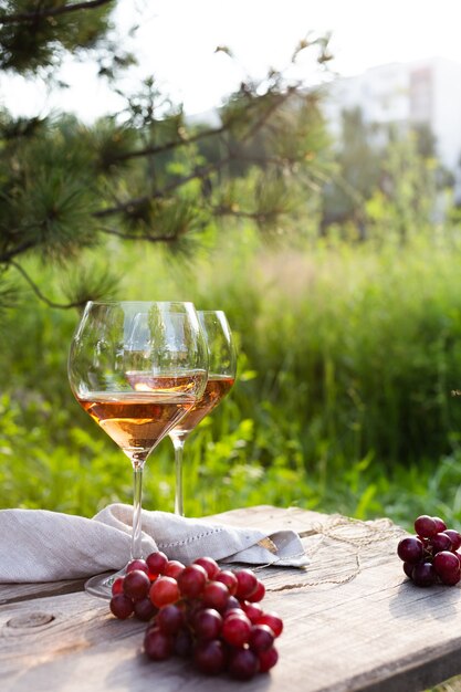 Deux verres à vin et raisins sur une table en bois