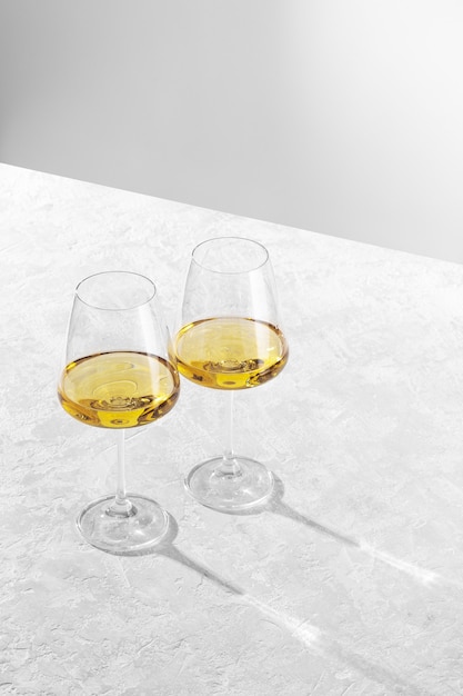 Deux verres à vin se tiennent contre un blanc