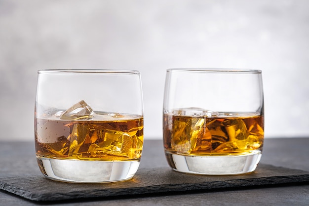 Deux verres de whisky sur fond de pierre grise