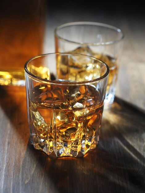 Photo deux verres de whisky sur les rochers sur une table en bois