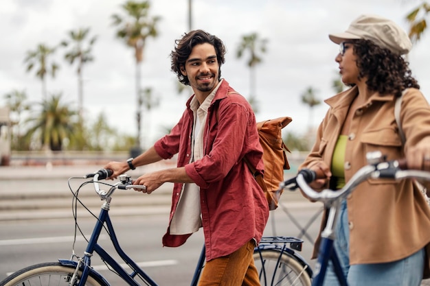 Photo deux voyageurs heureux visitent l'espagne et font du tourisme tout en écartant leurs vélos rénaux