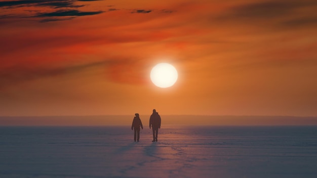 Photo les deux voyageurs avec des sacs à dos marchant sur un beau fond de coucher de soleil