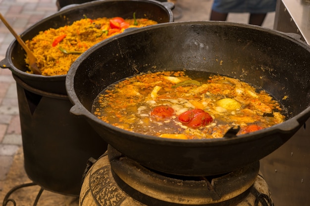 Deux woks profonds avec des épices et des légumes colorés