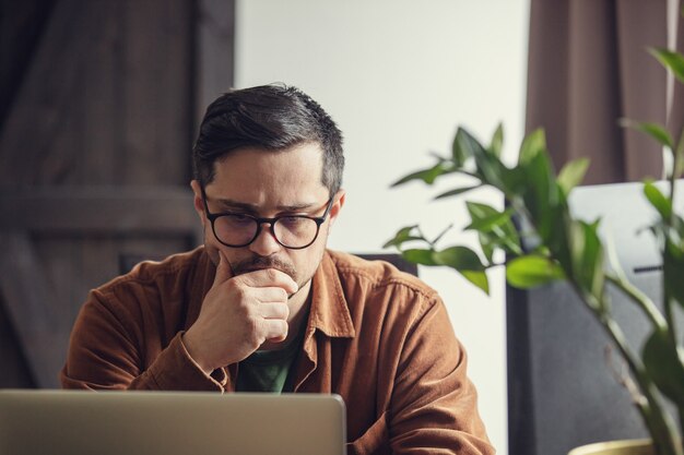 Développeur fatigué travaillant avec un ordinateur portable à la maison