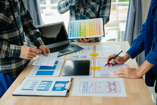 Développeur UX et concepteur d'interface utilisateur remue-méninges sur la conception filaire de l'interface d'application mobile avec breif client et code couleur au bureau modernexA