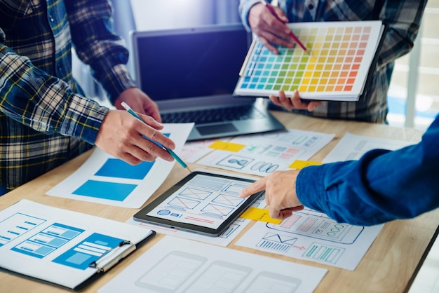 Développeur UX et concepteur d'interface utilisateur remue-méninges sur la conception filaire de l'interface d'application mobile avec breif client et code couleur au bureau modernexA