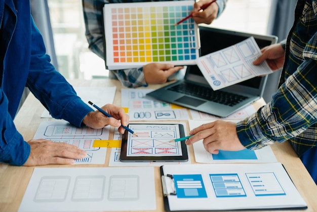 Développeur UX et concepteur d'interface utilisateur remue-méninges sur la conception filaire de l'interface d'application mobile avec breif client et code couleur au bureau modernexA