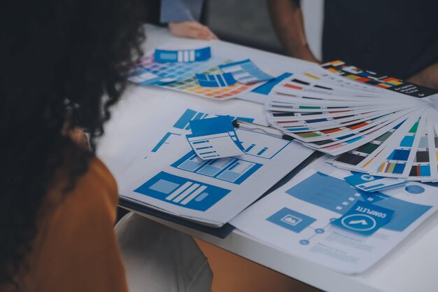 Le développeur ux et le concepteur ui utilisent le brainstorming de réalité augmentée sur la conception d'interfaces d'applications mobiles sur le bureau d'un bureau moderneAgence de développement numérique créative