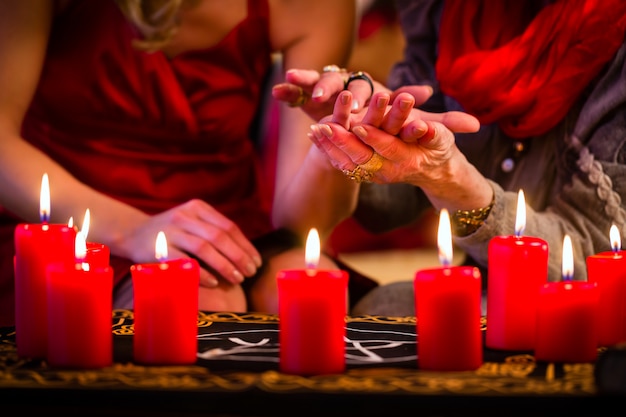 Un devin pendant une séance de chiromancie