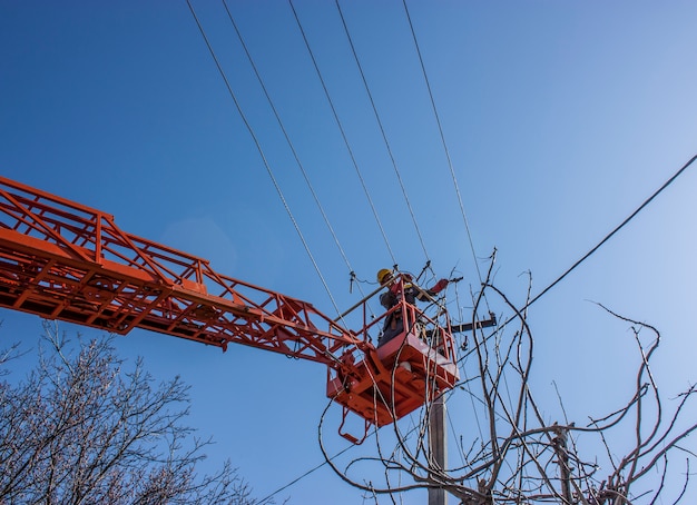 devoir de ligne de travail ligne fixe de puissance sur le câble électrique avec des plates-formes aériennes de travail