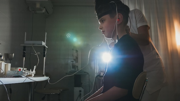 Diagnostic des enfants de la santé - optométriste mis sur l'équipement cerveau-œil pour garçon patient - clinique d'ophtalmologie, gros plan