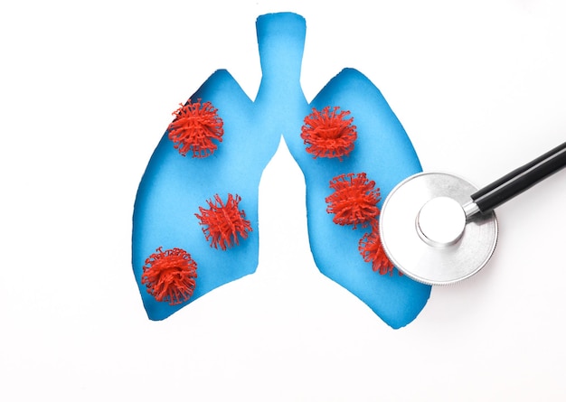 Diagnostique de la tuberculose ou de la pneumonie Trou coupé sur papier en forme de poumon humain avec des molécules de virus et un stéthoscope