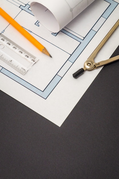 Diagrammes de maison roulée et accessoires pour dessiner allongé sur un dessin de construction sur un espace noir