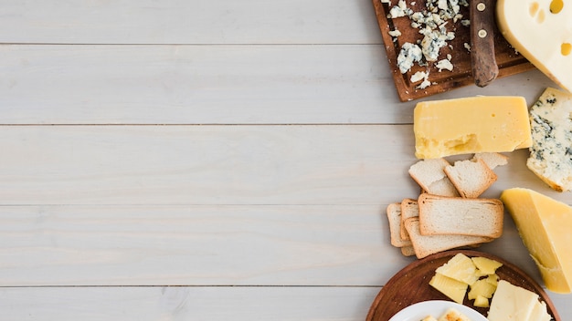 Différent type de fromage avec du pain sur une table en bois