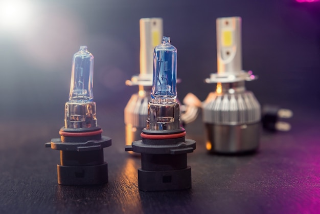 Différentes ampoules LED pour voiture isolée sur fond isolé en bois noir. Technologie d'éclairage automobile moderne. Phare automatique