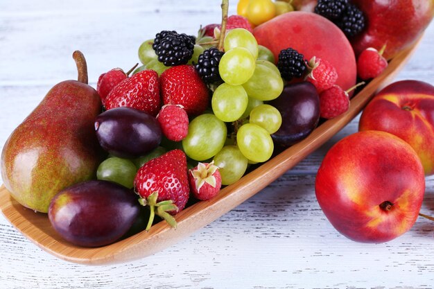 Différentes baies et fruits sur table en bois agrandi