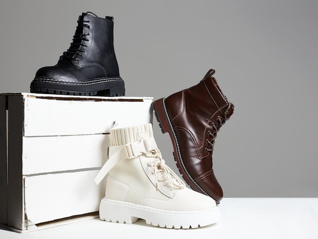 Différentes bottes tendance avec boîte en bois blanc