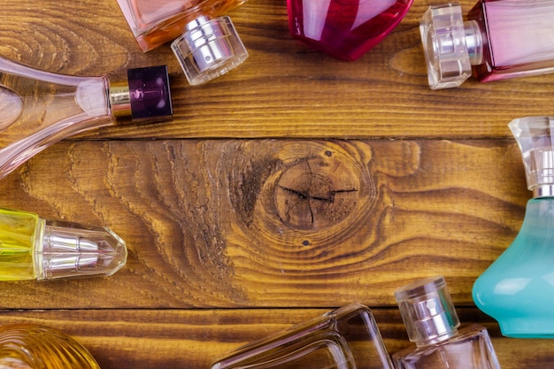 Différentes bouteilles de parfum sur le fond en bois Vue de dessus copie espace