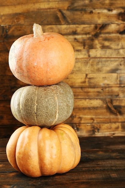 Différentes citrouilles mûres sur fond de bois