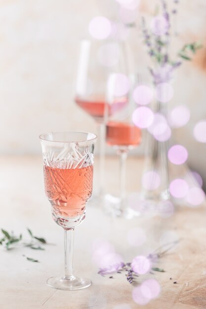 Différentes formes de verres de vin rosé sur fond clair.