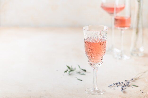 Différentes formes de verres de vin rosé sur fond clair.