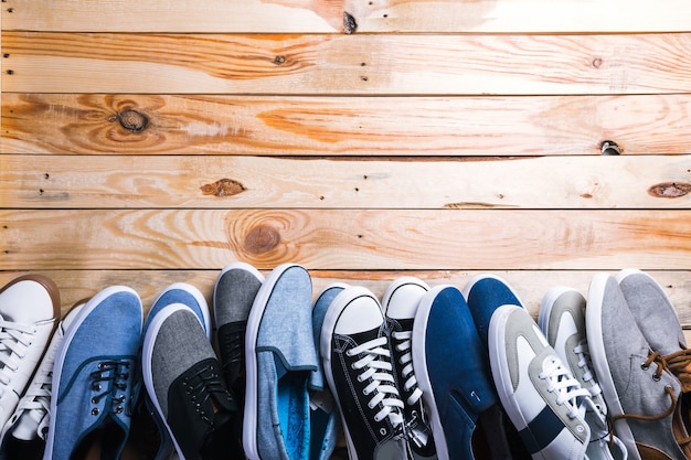 Différentes paires de baskets posées sur le plancher en bois