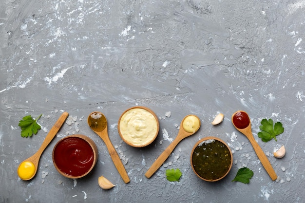 Photo différentes sauces en cuillères sur fond de table vue de dessus à plat