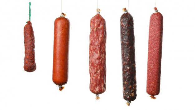 Différentes saucisses suspendues isolés sur blanc