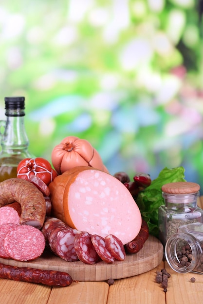 Différentes saucisses sur table en bois sur fond naturel